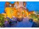 Outdoor patio with stone arches, a fire pit, and comfortable seating under warm, inviting lighting at 27809 N Silverado Ranch Rd, Peoria, AZ 85383