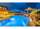 Backyard oasis at twilight, featuring a beautiful pool with rock waterfall and lush landscaping, ideal for relaxation at 27809 N Silverado Ranch Rd, Peoria, AZ 85383