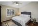 Cozy bedroom featuring a ceiling fan, window shutters, and an area rug on hardwood floors at 28897 N 94Th Pl, Scottsdale, AZ 85262