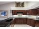 Modern kitchen featuring dark granite countertops and dark wood cabinets with a stainless steel appliance at 28897 N 94Th Pl, Scottsdale, AZ 85262