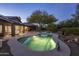 Inviting pool is adjacent to the house, with solar panels and surrounded by desert landscaping and mature trees at 28897 N 94Th Pl, Scottsdale, AZ 85262