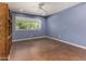 Bedroom with stylish blue walls, a ceiling fan, and a large window that offers scenic outdoor views at 3030 E Shangri La Rd, Phoenix, AZ 85028
