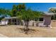 Quaint home with a well-maintained front yard, adorned with rose bushes and mature trees providing ample shade at 3030 E Shangri La Rd, Phoenix, AZ 85028