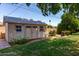 Well-maintained backyard storage shed offering practical storage solutions, surrounded by a lush green lawn and trees at 3030 E Shangri La Rd, Phoenix, AZ 85028