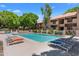 A refreshing pool with lounge chairs and a community area with mature landscaping and balconies at 3031 N Civic Center Plz # 317, Scottsdale, AZ 85251