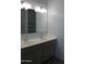 Bathroom featuring a double sink vanity, overhead lighting and large mirror at 30918 W Mulberry W Dr, Buckeye, AZ 85396