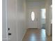 Hallway showcasing tile flooring, white walls, and a front door with glass insert, creating a welcoming entrance at 30918 W Mulberry W Dr, Buckeye, AZ 85396