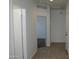 Bright hallway featuring tile flooring, white walls, and multiple doorways, offering a clean and modern feel at 30918 W Mulberry W Dr, Buckeye, AZ 85396