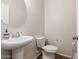 This half bathroom features a stylish pedestal sink, toilet, and neutral wall color at 3113 N 303Rd Dr, Buckeye, AZ 85396