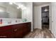 Bright bathroom featuring a double sink vanity with a dark wood finish and plank flooring at 3113 N 303Rd Dr, Buckeye, AZ 85396