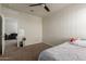 Cozy bedroom with carpet, ceiling fan, closet and an attached sitting area with a gray couch at 3113 N 303Rd Dr, Buckeye, AZ 85396