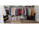Walk-in closet features wood-look floors and storage for clothes, shoes, and accessories at 3113 N 303Rd Dr, Buckeye, AZ 85396