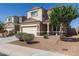 Attractive home with desert landscaping, a two-car garage, and inviting front porch with seating at 3113 N 303Rd Dr, Buckeye, AZ 85396