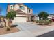 Charming two-story home showcasing a well-manicured front yard, a wide driveway, and a two car garage at 3113 N 303Rd Dr, Buckeye, AZ 85396