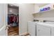 Functional laundry area showcasing side-by-side washer and dryer and organized closet with shelving at 3113 N 303Rd Dr, Buckeye, AZ 85396