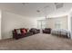 Spacious living room with carpet floors, ceiling fan, and lots of light at 3113 N 303Rd Dr, Buckeye, AZ 85396