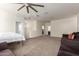 Spacious living room with carpet floors, ceiling fan, and lots of light at 3113 N 303Rd Dr, Buckeye, AZ 85396