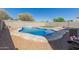 Backyard with in-ground pool, waterfall feature, fire pit, artificial turf, gravel and block wall at 3113 N 303Rd Dr, Buckeye, AZ 85396