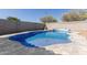 Sparkling blue swimming pool surrounded by stone patio and rock landscaping, set against a block fence at 3113 N 303Rd Dr, Buckeye, AZ 85396