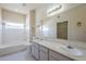 Bright bathroom featuring a double sink vanity, bathtub, and window with mountain views at 3236 E Chandler Blvd # 2003, Phoenix, AZ 85048