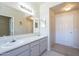 Bright bathroom featuring a double sink vanity, cabinets and a door to the hallway at 3236 E Chandler Blvd # 2003, Phoenix, AZ 85048