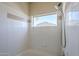 Bright white tiled bath and shower featuring neutral tile detail and a window to mountain views at 3236 E Chandler Blvd # 2003, Phoenix, AZ 85048