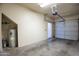 A bare two car garage featuring a water heater, lighting and roll up door at 3236 E Chandler Blvd # 2003, Phoenix, AZ 85048