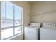 Convenient laundry room with a full-size washer and dryer next to a bright window at 3236 E Chandler Blvd # 2003, Phoenix, AZ 85048