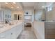 Bright primary bathroom featuring double sinks, granite countertops, and walk-in shower at 32567 N 133Rd Ave, Peoria, AZ 85383