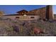 Striking community entrance featuring stone accents and desert landscaping, illuminated by evening light at 32567 N 133Rd Ave, Peoria, AZ 85383