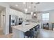 Spacious kitchen features stainless steel appliances, quartz countertops, and pendant lights over a seating island at 32567 N 133Rd Ave, Peoria, AZ 85383