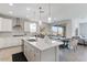 Open kitchen with a large island, quartz countertops, stainless appliances, and adjacent dining area at 32567 N 133Rd Ave, Peoria, AZ 85383