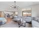 Open concept living room with modern chandelier, large sectional sofa, and seamless flow to the kitchen at 32567 N 133Rd Ave, Peoria, AZ 85383