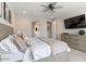 Bright main bedroom featuring a ceiling fan, TV, dresser, and ensuite bath at 32567 N 133Rd Ave, Peoria, AZ 85383