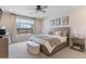 Comfortable main bedroom with carpet flooring, a ceiling fan, and a large window at 32567 N 133Rd Ave, Peoria, AZ 85383