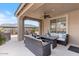 Covered patio with comfortable seating and an outdoor kitchen area at 32567 N 133Rd Ave, Peoria, AZ 85383