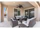 Covered patio with comfortable seating and an outdoor kitchen area at 32567 N 133Rd Ave, Peoria, AZ 85383