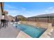 Sparkling pool with a waterfall feature, lounge chairs, and outdoor seating at 32567 N 133Rd Ave, Peoria, AZ 85383