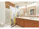 Well-lit bathroom featuring double sinks, mosaic tiles, and a shower with decorative curtain at 3381 E Canary Way, Chandler, AZ 85286