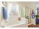 Bright bathroom with a bathtub, walk-in shower and large, decorative glass window at 3381 E Canary Way, Chandler, AZ 85286
