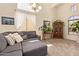 Bright living room with vaulted ceilings, plush gray sofa, decorative pillows, and large windows with sheer curtains at 3381 E Canary Way, Chandler, AZ 85286