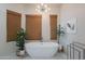 Bright bathroom with a freestanding tub, woven shades, and modern light fixture at 3405 E Knox Rd, Phoenix, AZ 85044