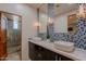 Modern bathroom with dual sinks, blue mosaic tiles, and a glass shower at 3405 E Knox Rd, Phoenix, AZ 85044