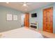Light-filled bedroom with wood floors, ceiling fan, and natural wood door at 3405 E Knox Rd, Phoenix, AZ 85044