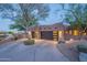 Exterior view of the garage and driveway of this desert home surrounded by mature trees at 3405 E Knox Rd, Phoenix, AZ 85044