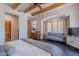 Inviting main bedroom with dark wood floors, king bed, and wood beam ceiling details at 3405 E Knox Rd, Phoenix, AZ 85044