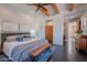 Relaxing main bedroom with wood beam ceilings, a king-sized bed, and a sitting bench at 3405 E Knox Rd, Phoenix, AZ 85044