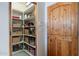 Walk-in pantry with shelving, baskets, and wooden door at 3405 E Knox Rd, Phoenix, AZ 85044