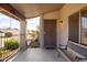 Inviting covered front porch with a security door, seating and desert landscaping at 3821 W Woodridge Dr, Glendale, AZ 85308