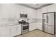 The renovated kitchen features stainless steel appliances, white cabinets, and granite countertops at 3847 S 63Rd Dr, Phoenix, AZ 85043